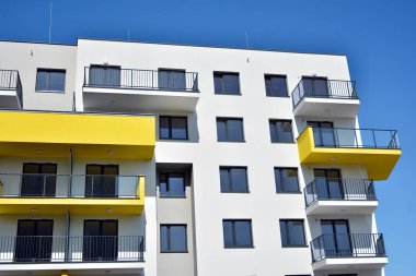 Mavi gökyüzü olan güneşli bir günde modern apartman binaları. Modern bir apartmanın cephesi