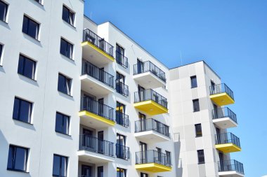 Mavi gökyüzü olan güneşli bir günde modern apartman binaları. Modern bir apartmanın cephesi