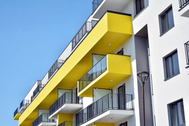 Mavi gökyüzü olan güneşli bir günde modern apartman binaları. Modern bir apartmanın cephesi