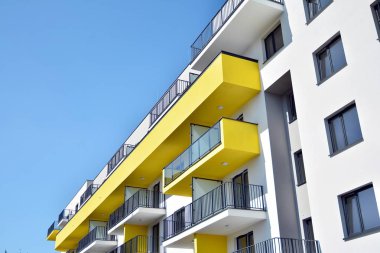 Mavi gökyüzü olan güneşli bir günde modern apartman binaları. Modern bir apartmanın cephesi
