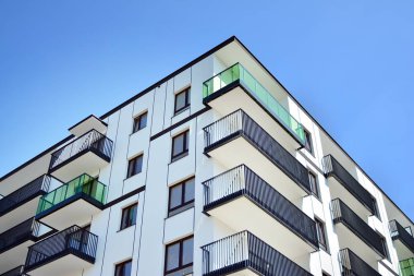 Mavi gökyüzü olan güneşli bir günde modern apartman binaları. Modern bir apartmanın cephesi