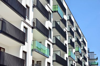 Mavi gökyüzü olan güneşli bir günde modern apartman binaları. Modern bir apartmanın cephesi