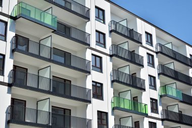 Mavi gökyüzü olan güneşli bir günde modern apartman binaları. Modern bir apartmanın cephesi