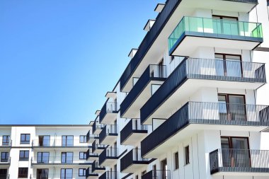 Mavi gökyüzü olan güneşli bir günde modern apartman binaları. Modern bir apartmanın cephesi