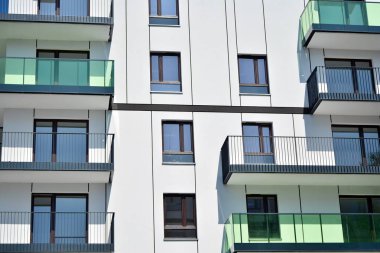 Mavi gökyüzü olan güneşli bir günde modern apartman binaları. Modern bir apartmanın cephesi