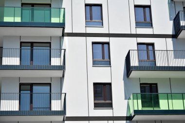 Mavi gökyüzü olan güneşli bir günde modern apartman binaları. Modern bir apartmanın cephesi