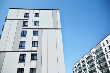 Mavi gökyüzü olan güneşli bir günde modern apartman binaları. Modern bir apartmanın cephesi