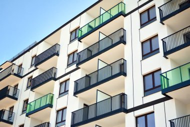 Mavi gökyüzü olan güneşli bir günde modern apartman binaları. Modern bir apartmanın cephesi