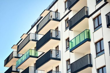 Mavi gökyüzü olan güneşli bir günde modern apartman binaları. Modern bir apartmanın cephesi