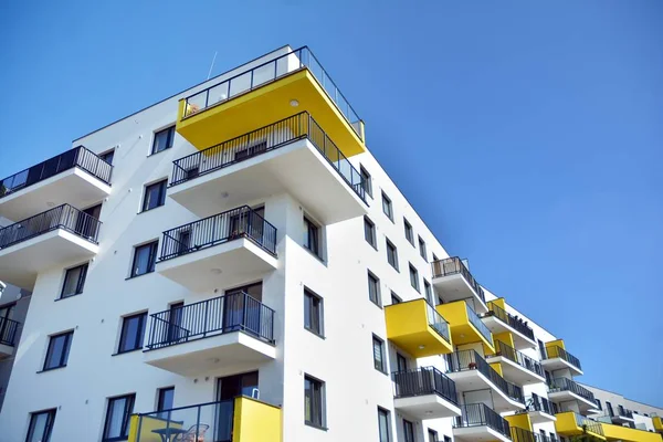 Mavi gökyüzü olan güneşli bir günde modern apartman binaları. Modern bir apartmanın cephesi