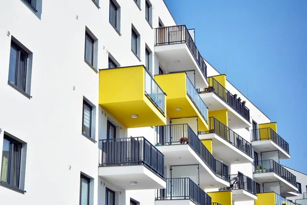 Mavi gökyüzü olan güneşli bir günde modern apartman binaları. Modern bir apartmanın cephesi