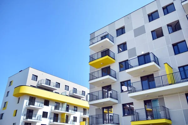 Mavi gökyüzü olan güneşli bir günde modern apartman binaları. Modern bir apartmanın cephesi