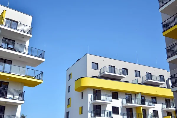 Mavi gökyüzü olan güneşli bir günde modern apartman binaları. Modern bir apartmanın cephesi