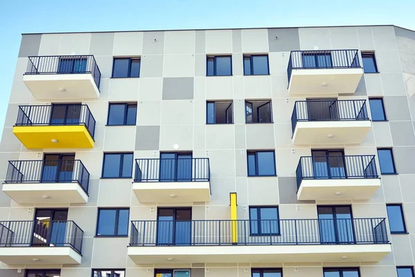 Mavi gökyüzü olan güneşli bir günde modern apartman binaları. Modern bir apartmanın cephesi
