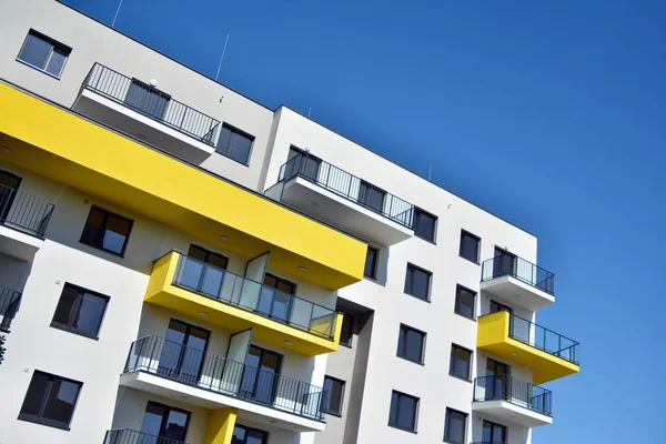 Mavi gökyüzü olan güneşli bir günde modern apartman binaları. Modern bir apartmanın cephesi