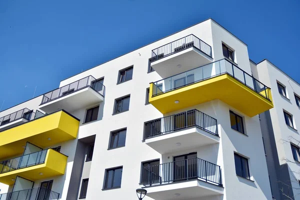 Mavi gökyüzü olan güneşli bir günde modern apartman binaları. Modern bir apartmanın cephesi