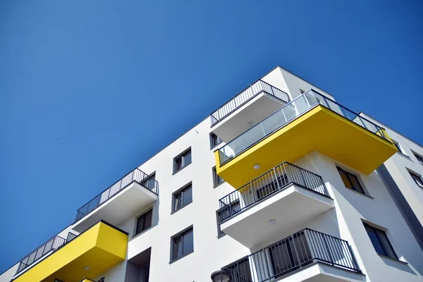 Mavi gökyüzü olan güneşli bir günde modern apartman binaları. Modern bir apartmanın cephesi