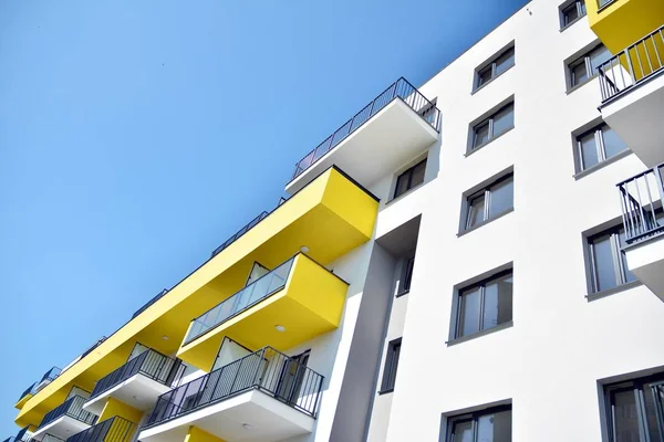 Mavi gökyüzü olan güneşli bir günde modern apartman binaları. Modern bir apartmanın cephesi