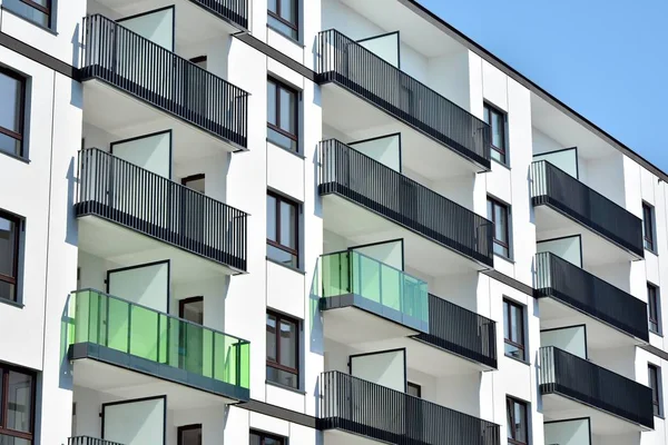 Mavi gökyüzü olan güneşli bir günde modern apartman binaları. Modern bir apartmanın cephesi