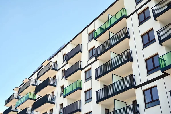 Mavi gökyüzü olan güneşli bir günde modern apartman binaları. Modern bir apartmanın cephesi