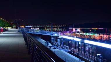 Varşova, Polonya. 25 Ağustos 2019. Vistulan Bulvarı, Varşova'daki Vistula Nehri'nin batı yakasında geceleyin. Gece Vistula nehri kıyısında gezinti.