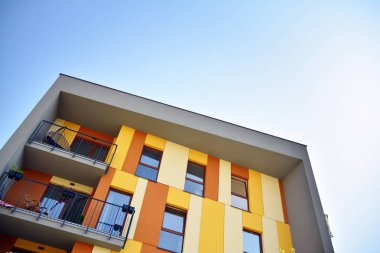 Mavi gökyüzü olan güneşli bir günde modern apartman binaları. Modern bir apartmanın cephesi