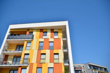 Mavi gökyüzü olan güneşli bir günde modern apartman binaları. Modern bir apartmanın cephesi