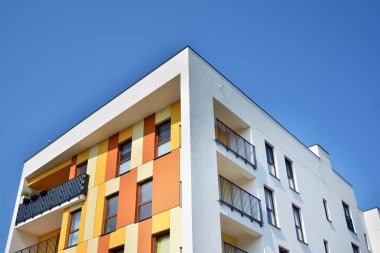Mavi gökyüzü olan güneşli bir günde modern apartman binaları. Modern bir apartmanın cephesi