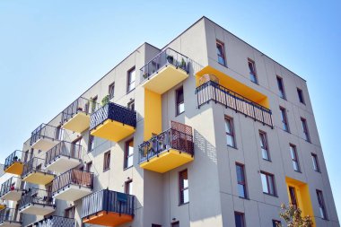Mavi gökyüzü olan güneşli bir günde modern apartman binaları. Modern bir apartmanın cephesi