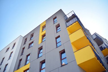 Mavi gökyüzü olan güneşli bir günde modern apartman binaları. Modern bir apartmanın cephesi