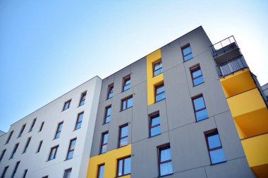 Mavi gökyüzü olan güneşli bir günde modern apartman binaları. Modern bir apartmanın cephesi
