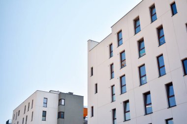 Mavi gökyüzü olan güneşli bir günde modern apartman binaları. Modern bir apartmanın cephesi