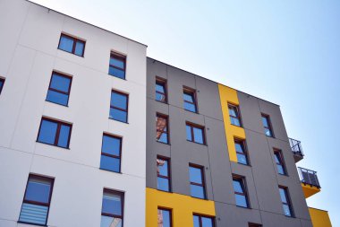 Mavi gökyüzü olan güneşli bir günde modern apartman binaları. Modern bir apartmanın cephesi