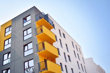 Mavi gökyüzü olan güneşli bir günde modern apartman binaları. Modern bir apartmanın cephesi