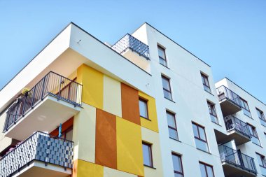 Mavi gökyüzü olan güneşli bir günde modern apartman binaları. Modern bir apartmanın cephesi