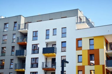 Mavi gökyüzü olan güneşli bir günde modern apartman binaları. Modern bir apartmanın cephesi