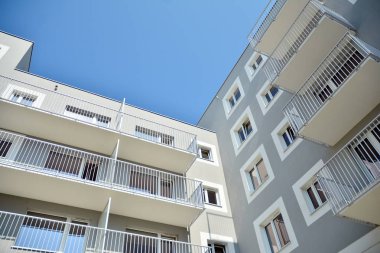 Mavi gökyüzü olan güneşli bir günde modern apartman binaları. Modern bir apartmanın cephesi