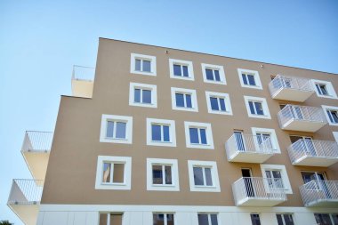 Mavi gökyüzü olan güneşli bir günde modern apartman binaları. Modern bir apartmanın cephesi