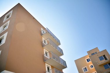 Mavi gökyüzü olan güneşli bir günde modern apartman binaları. Modern bir apartmanın cephesi