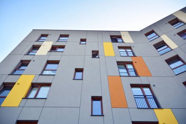 Mavi gökyüzü olan güneşli bir günde modern apartman binaları. Modern bir apartmanın cephesi