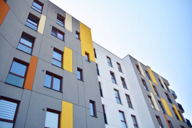 Mavi gökyüzü olan güneşli bir günde modern apartman binaları. Modern bir apartmanın cephesi