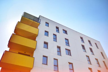 Mavi gökyüzü olan güneşli bir günde modern apartman binaları. Modern bir apartmanın cephesi