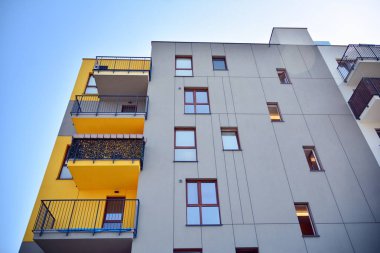 Mavi gökyüzü olan güneşli bir günde modern apartman binaları. Modern bir apartmanın cephesi