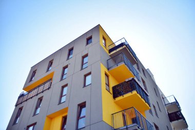 Mavi gökyüzü olan güneşli bir günde modern apartman binaları. Modern bir apartmanın cephesi