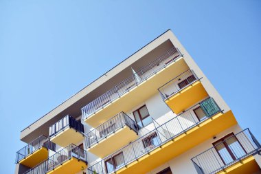 Mavi gökyüzü olan güneşli bir günde modern apartman binaları. Modern bir apartmanın cephesi