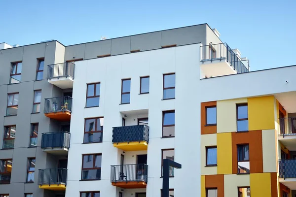 Mavi gökyüzü olan güneşli bir günde modern apartman binaları. Modern bir apartmanın cephesi