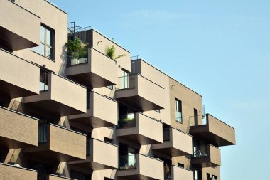 Mavi gökyüzü olan güneşli bir günde modern apartman binaları. Modern bir apartmanın cephesi