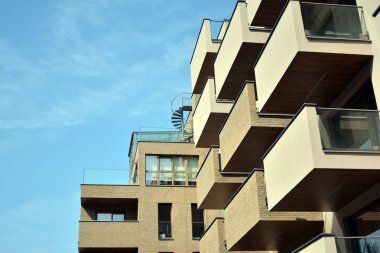 Mavi gökyüzü olan güneşli bir günde modern apartman binaları. Modern bir apartmanın cephesi