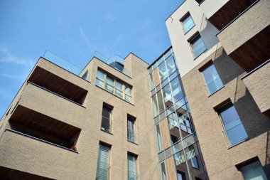 Mavi gökyüzü olan güneşli bir günde modern apartman binaları. Modern bir apartmanın cephesi