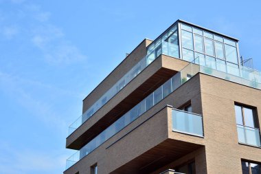 Mavi gökyüzü olan güneşli bir günde modern apartman binaları. Modern bir apartmanın cephesi